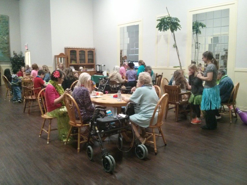 Residents and visitors gathered around tables in the common room