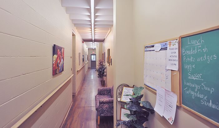 A bright hallway with handrails and an activity board