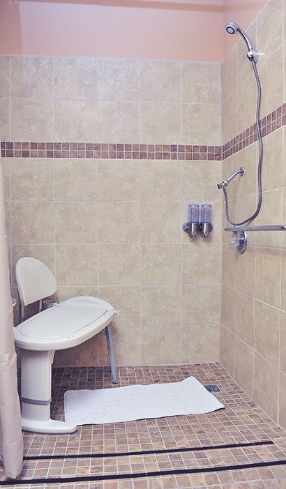 A walk-in shower with a seat and grab bars