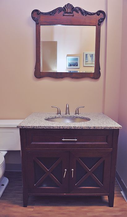A wooden vanity and mirror in a washroom